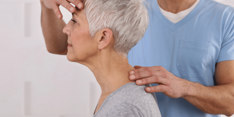 A person is getting their neck checked by an osteopath.